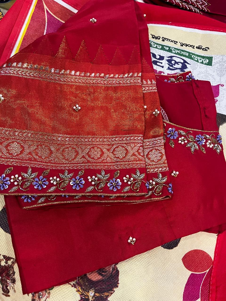 Red saree with gold zari borders and floral embroidered trim details