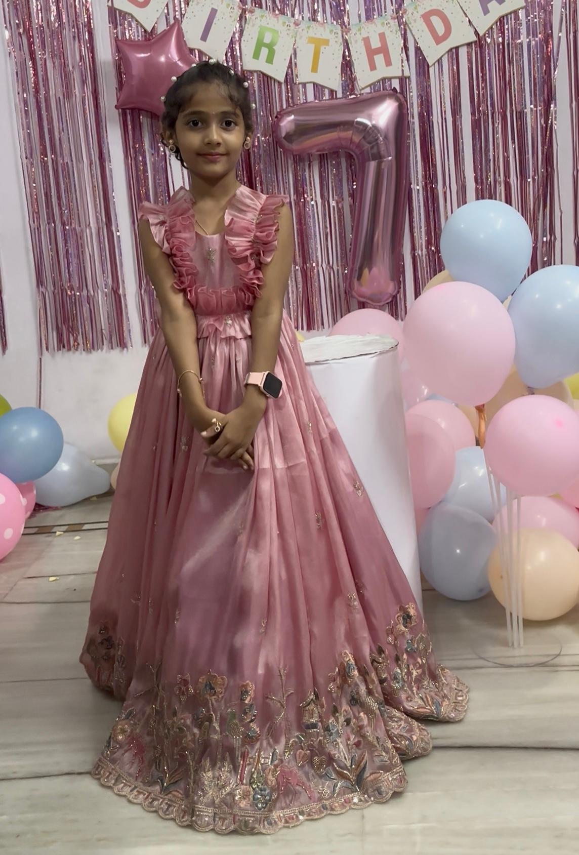 Mauve gown with ruffled neckline and ornate embroidered hem