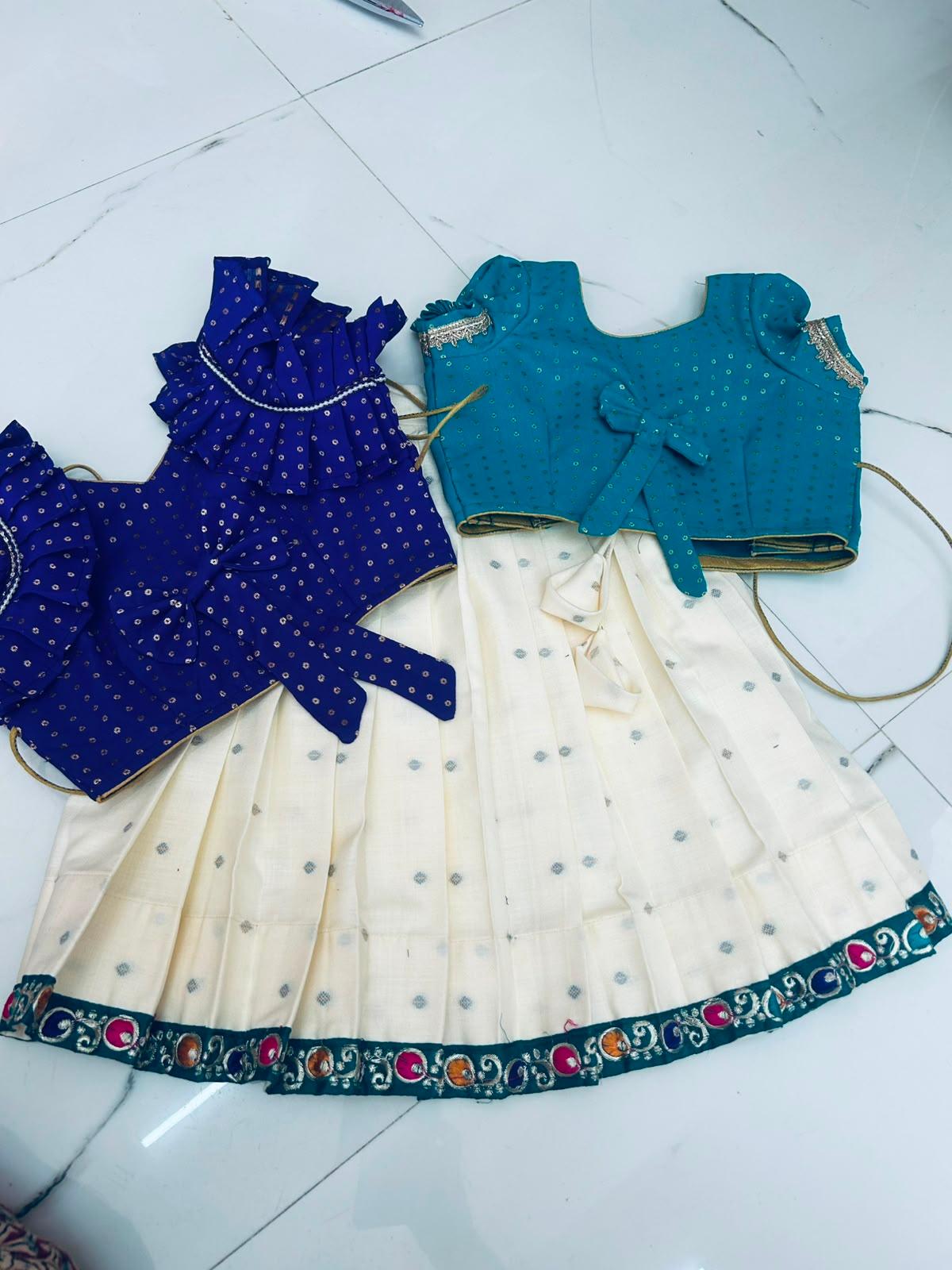 Girls traditional dress with blue blouse, cream skirt and embroidered border