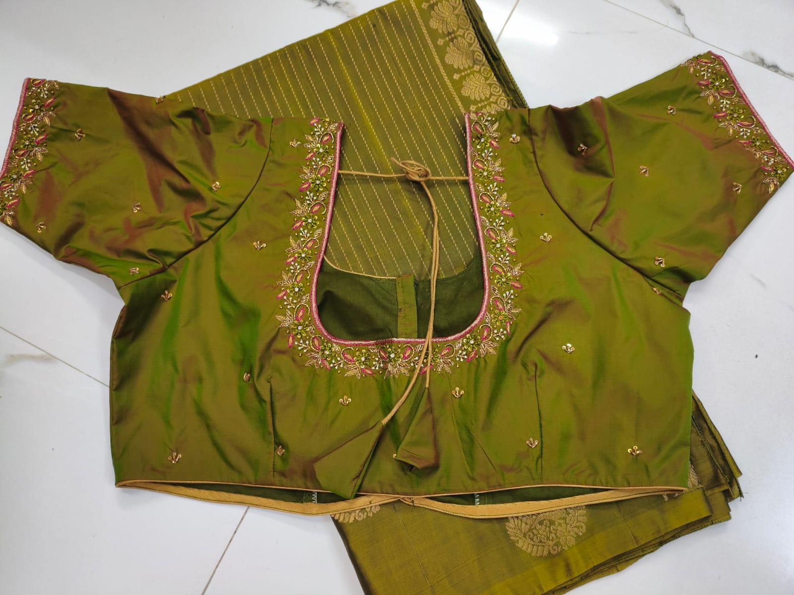 Green silk blouse with pink embroidered neckline and gold zari accents