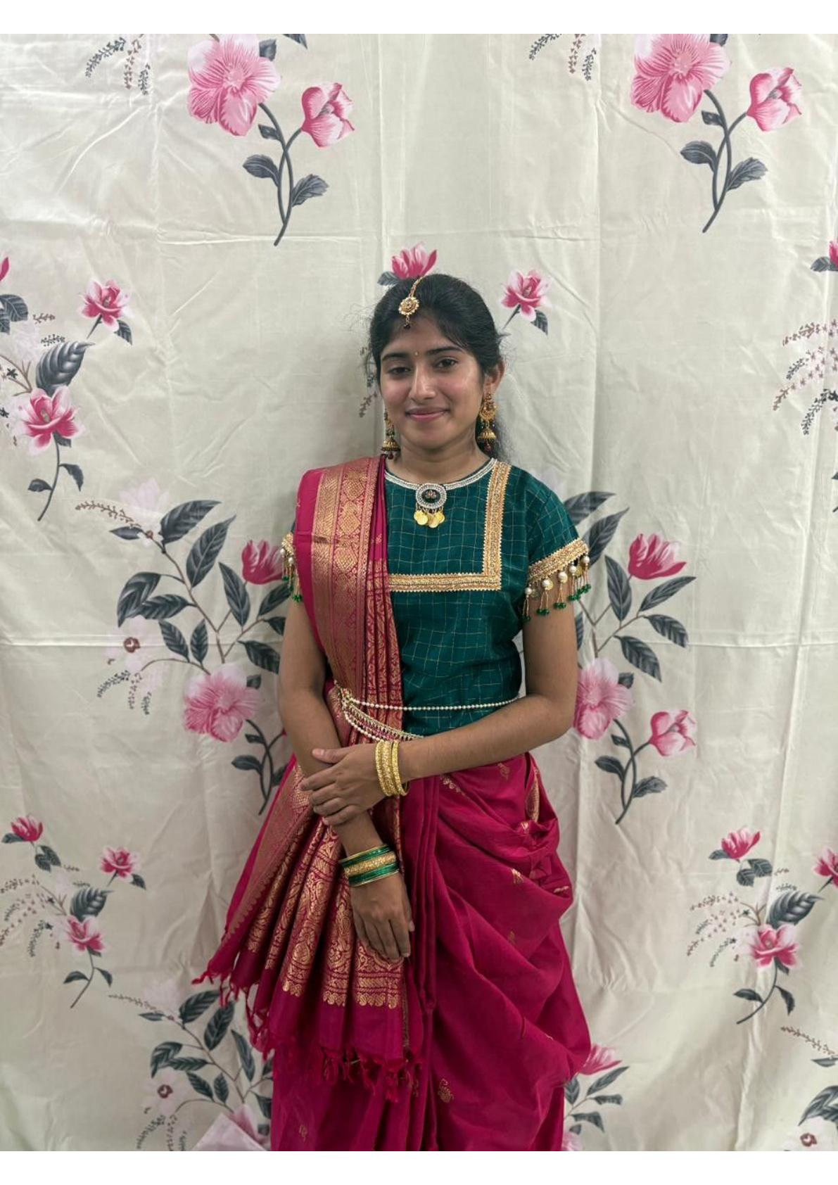 Dark green blouse with gold zari borders paired with maroon silk saree
