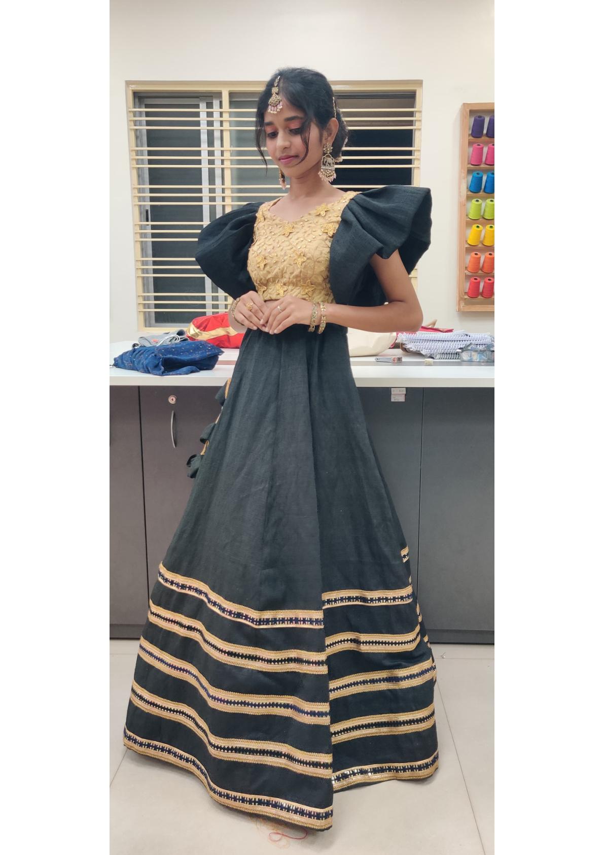 Black half saree with gold zari embroidered striped border and gold blouse