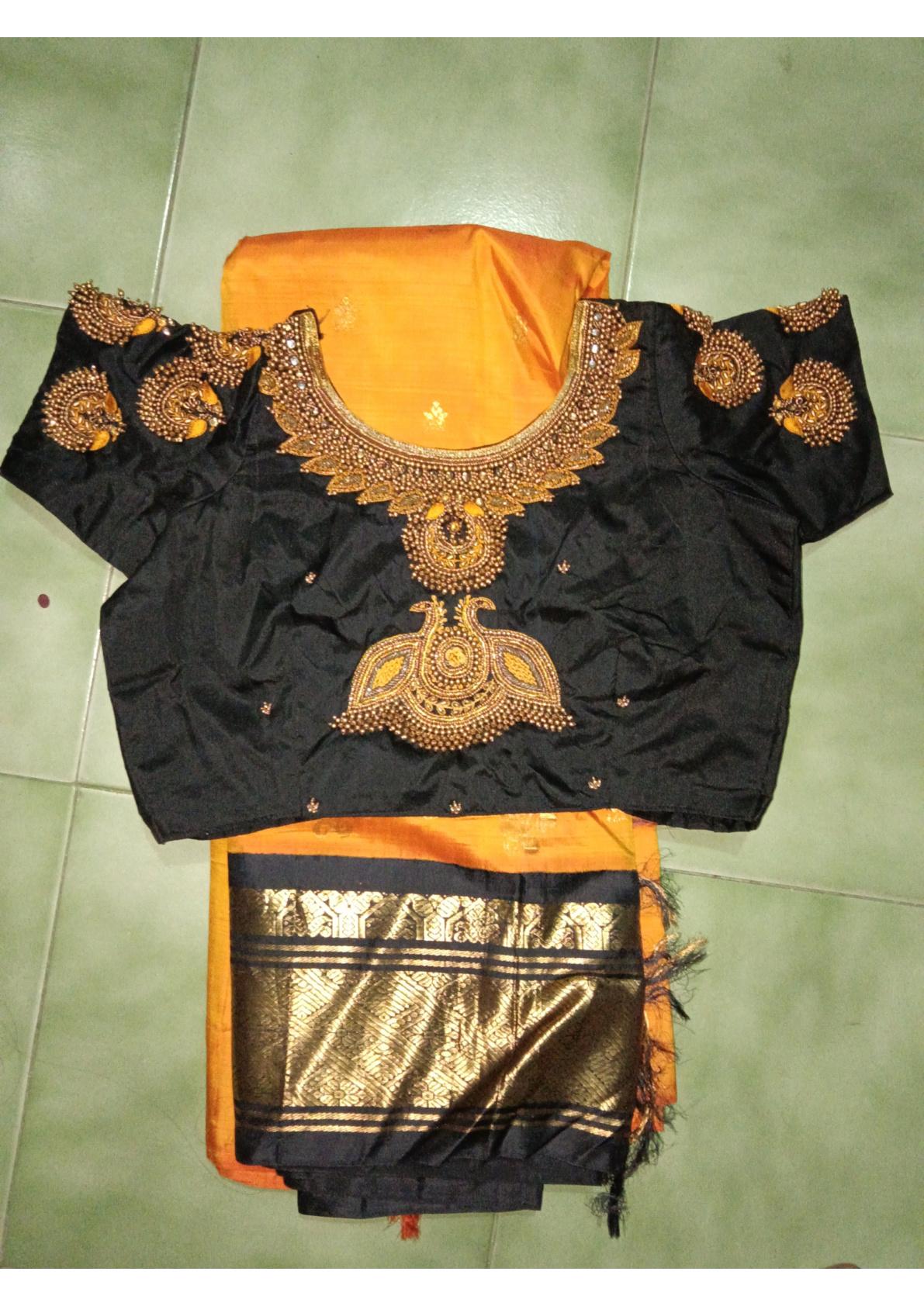 Black designer blouse with gold maggam work and orange silk saree
