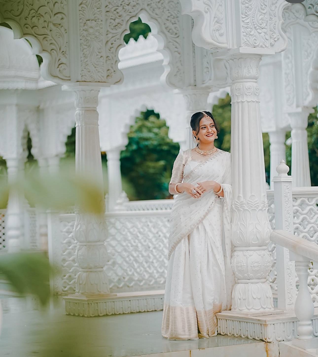 Cream silk saree with pearl embellishments and ornate blouse