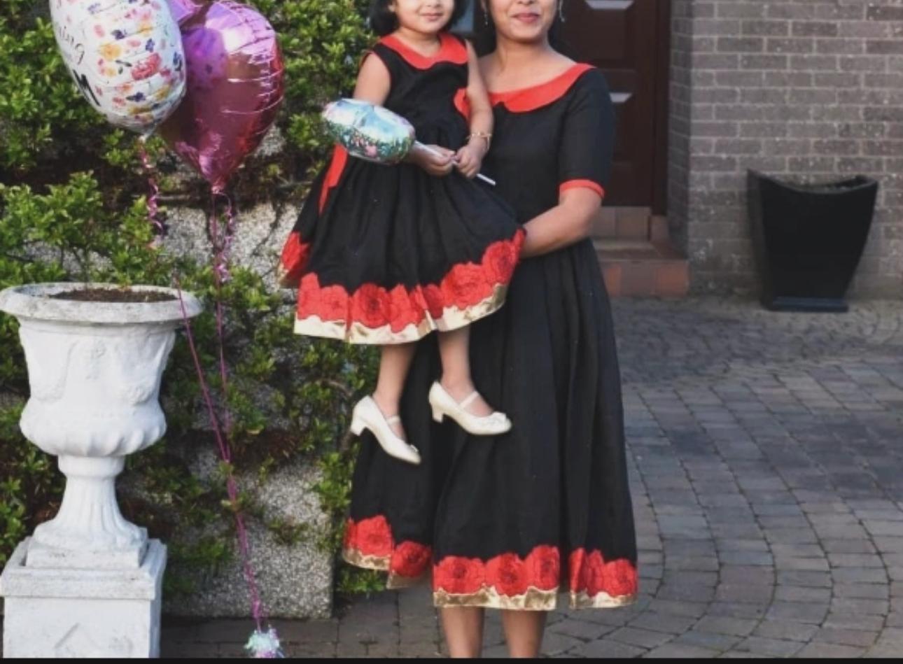 Black frock with red floral embroidery trim and gold detailing