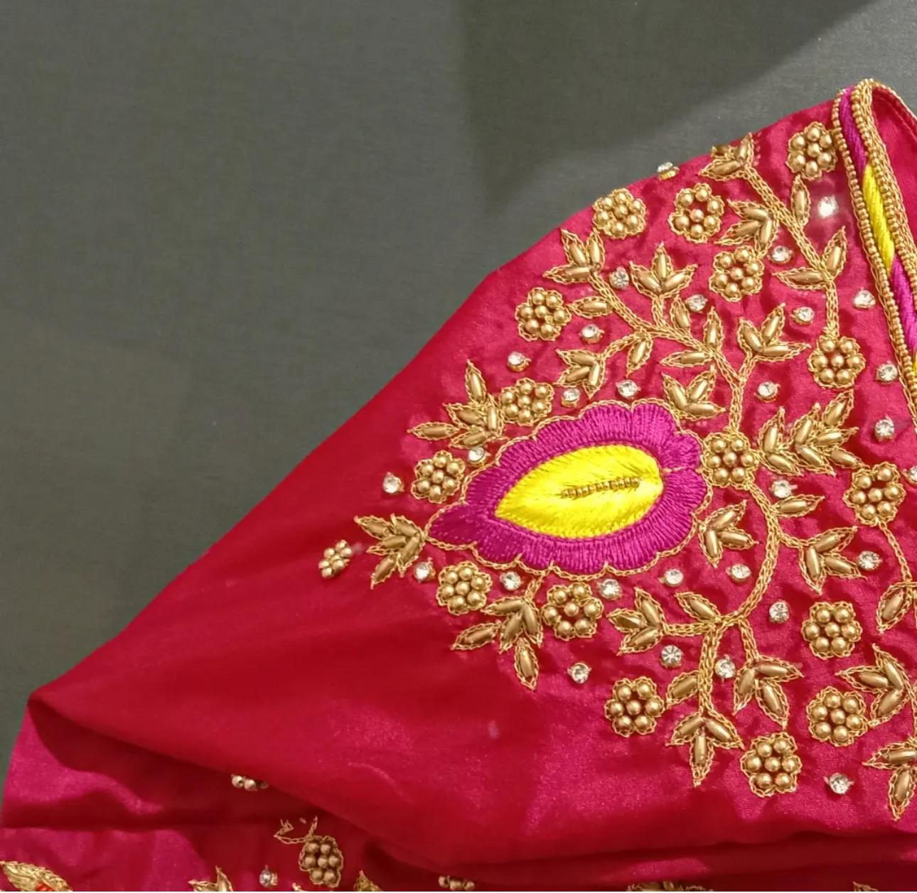 Magenta bridal blouse with gold zari floral embroidery and yellow maggam work