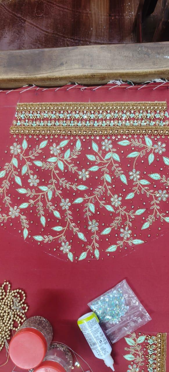 Red saree with turquoise and gold zari floral embroidery work