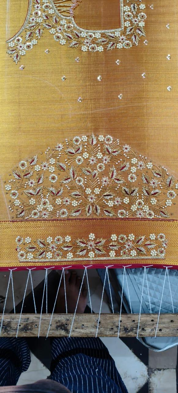Gold silk saree with intricate floral zari and maggam work embroidery