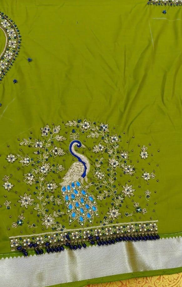 Lime green saree with blue peacock embroidery and floral embellishments