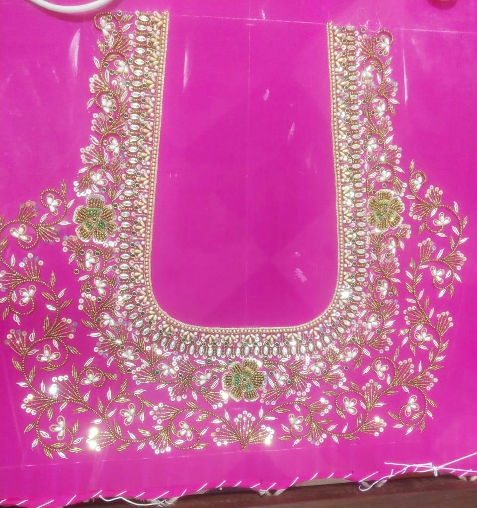 Bright pink bridal blouse with elaborate gold zari and pearl embroidery