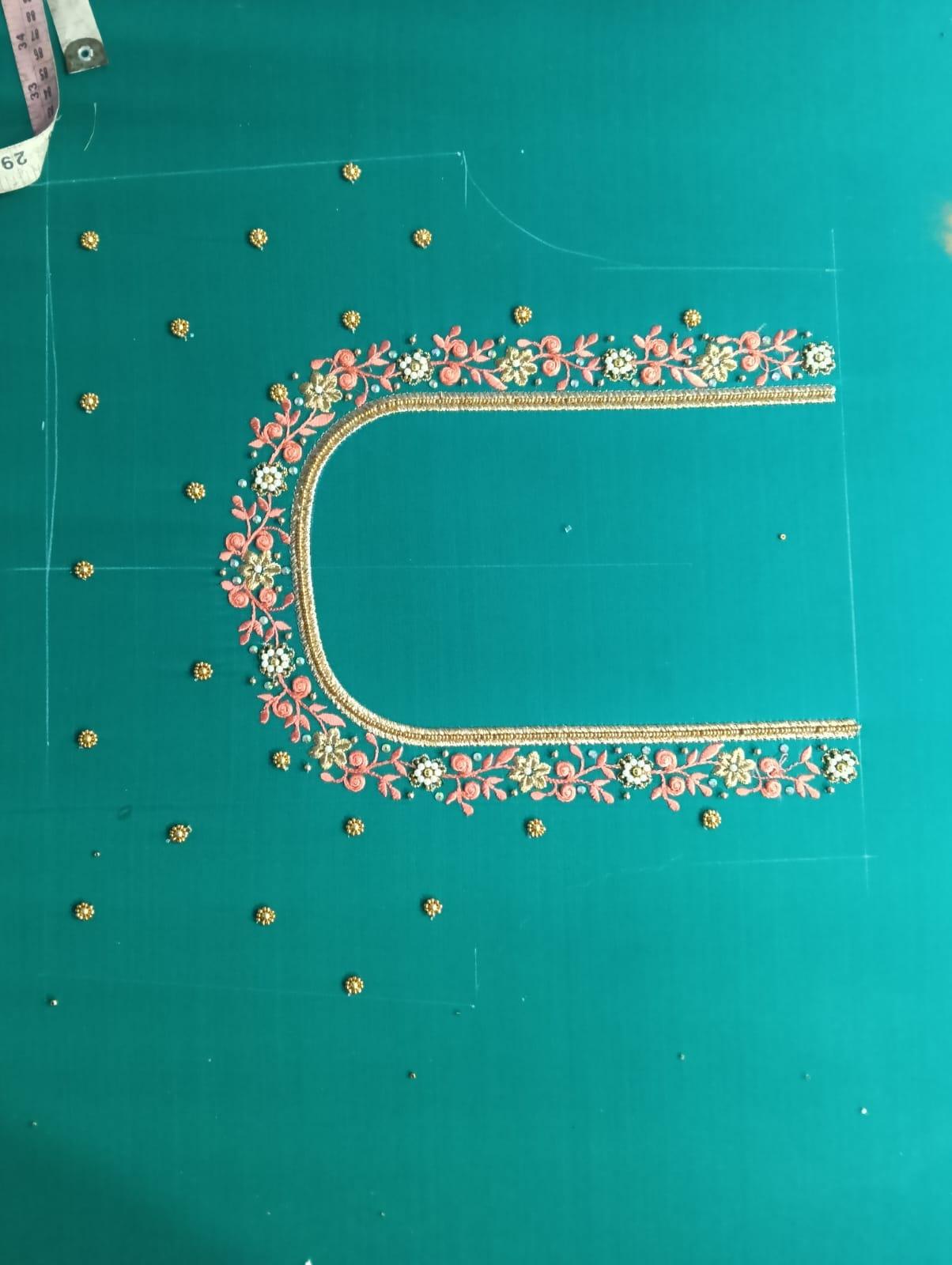 Teal blouse with ornate floral embroidery and gold zari border design