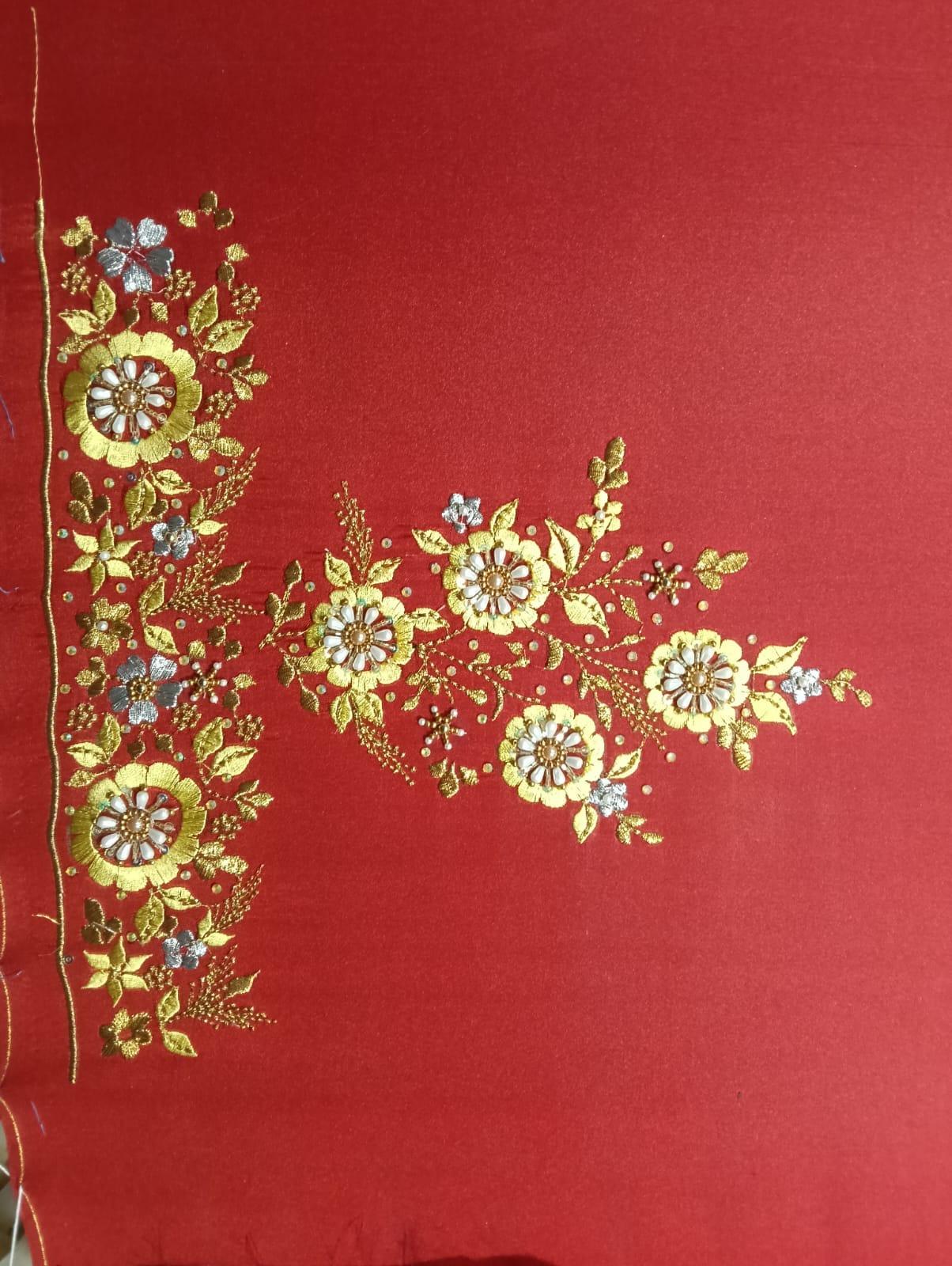 Red saree with gold zari floral embroidery and blue accents