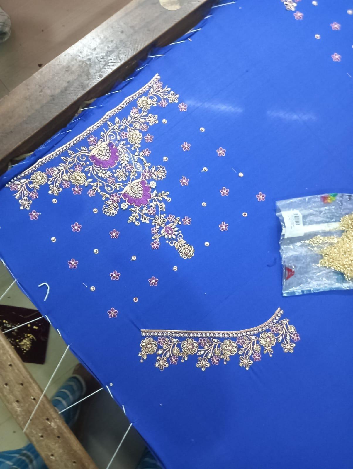 Royal blue saree with gold zari floral embroidery and purple accents