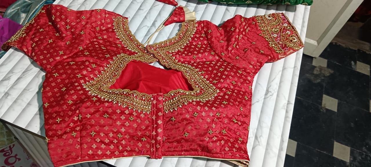 Red bridal blouse with gold zari embroidery and intricate maggam work