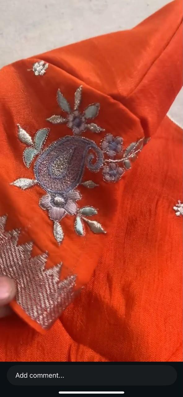 Bright orange blouse with purple floral embroidery and metallic detailing