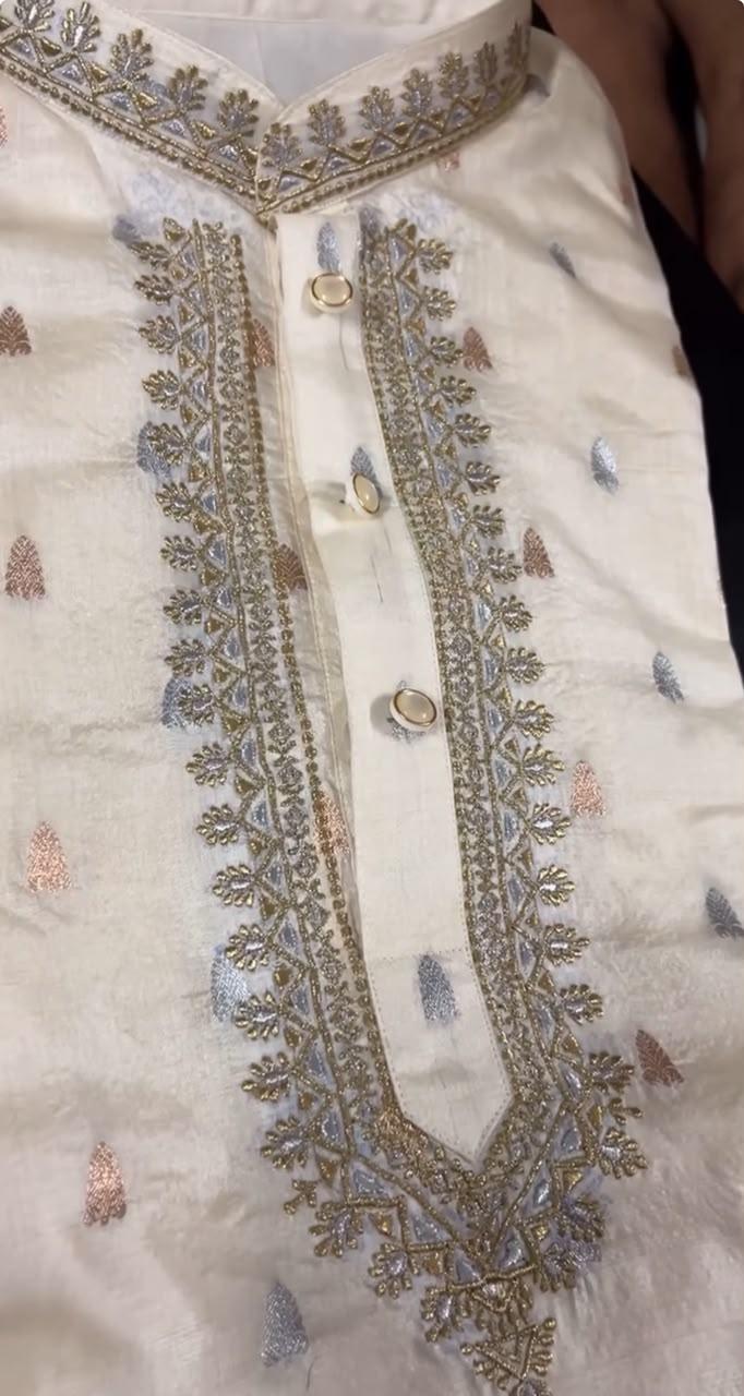 Cream bridal blouse with intricate gold zari embroidery and floral motifs
