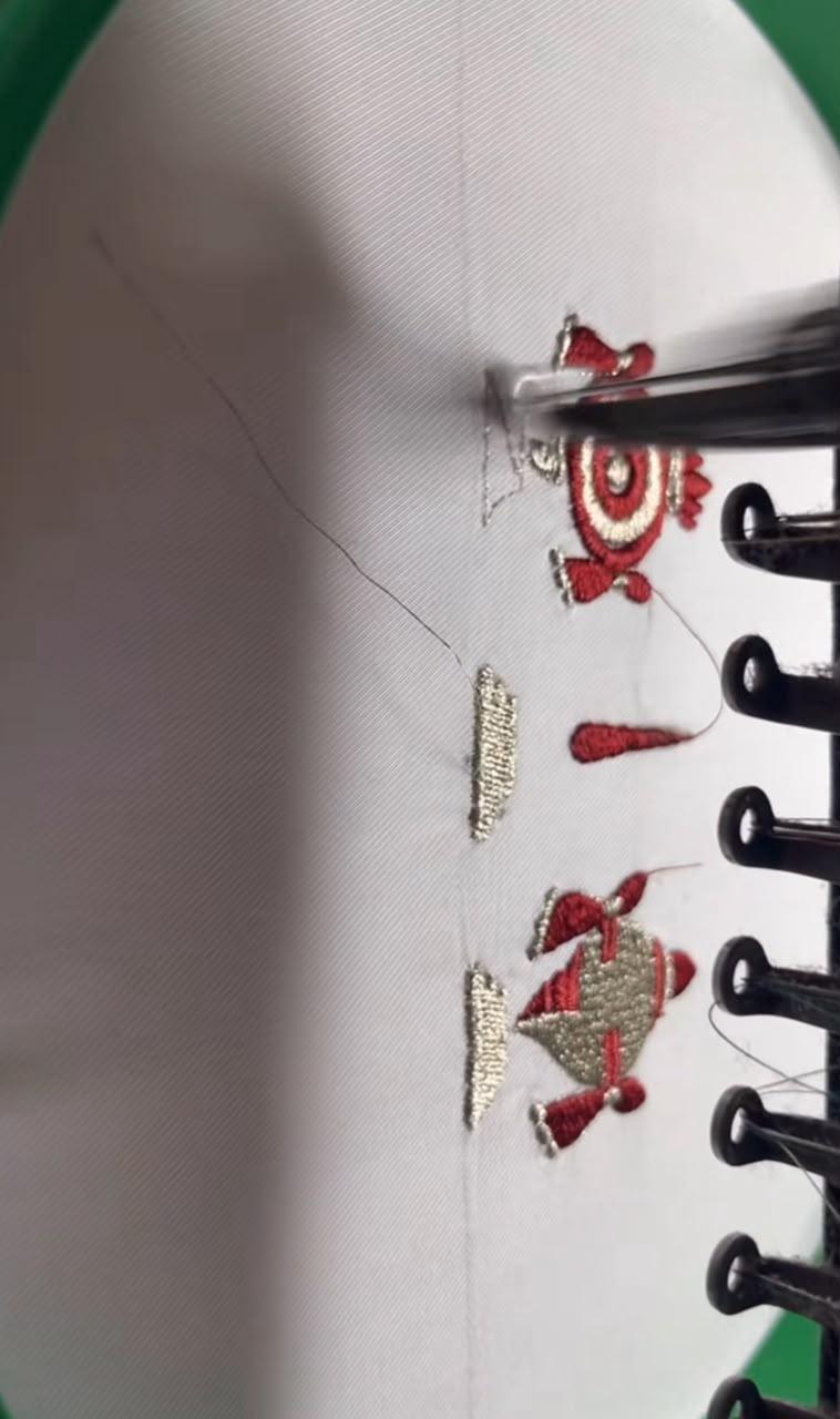 White blouse with red and gold embroidered design and lace-up closure