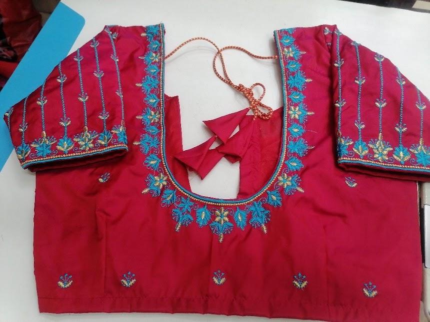 Red bridal blouse with turquoise maggam work and embroidered neckline