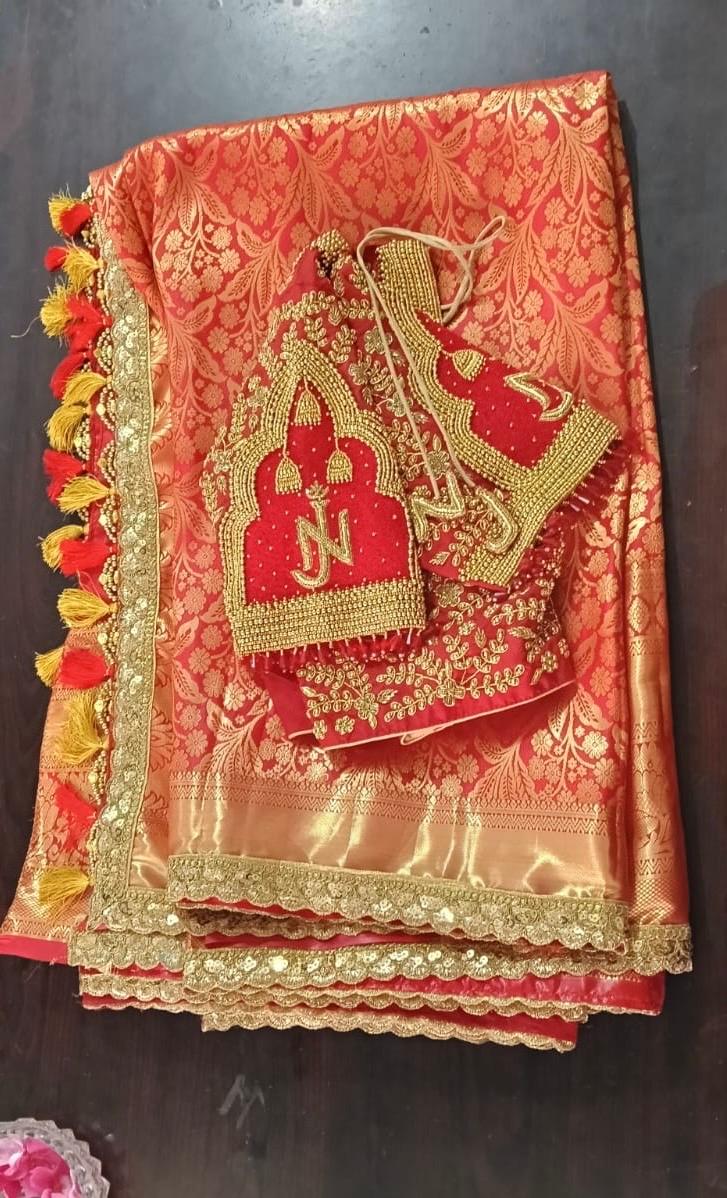 Red and gold silk saree with ornate zari embroidery and tassel border