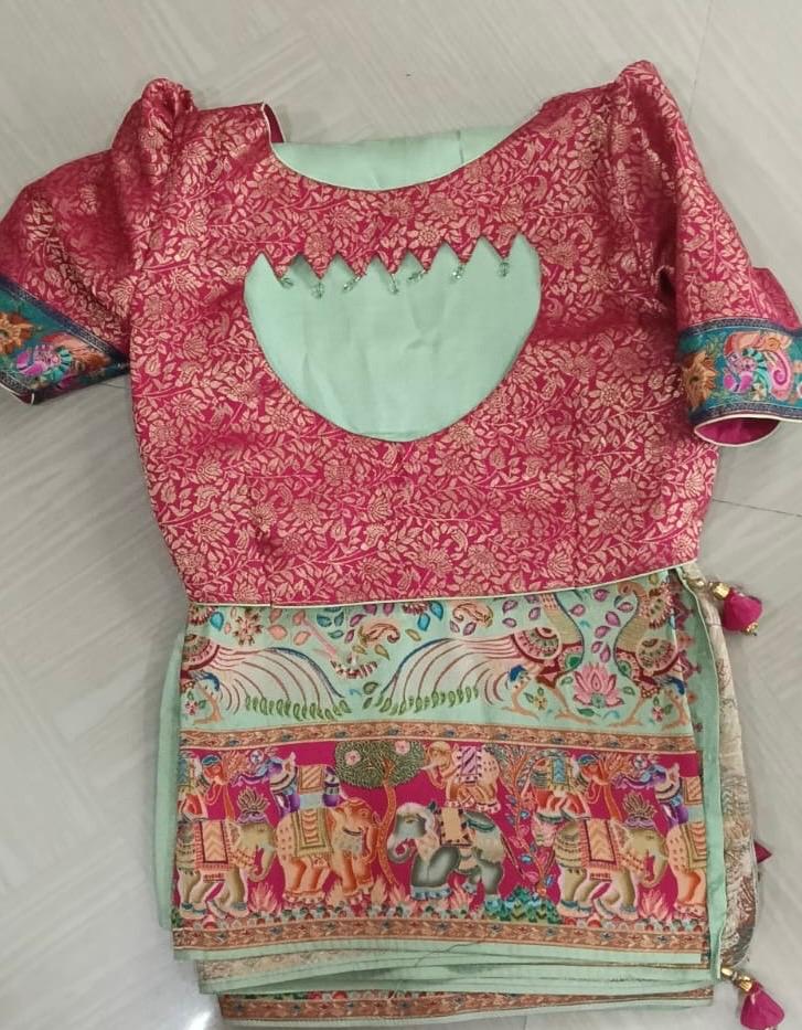 Maroon brocade blouse with mint green neckline and colorful patterned saree