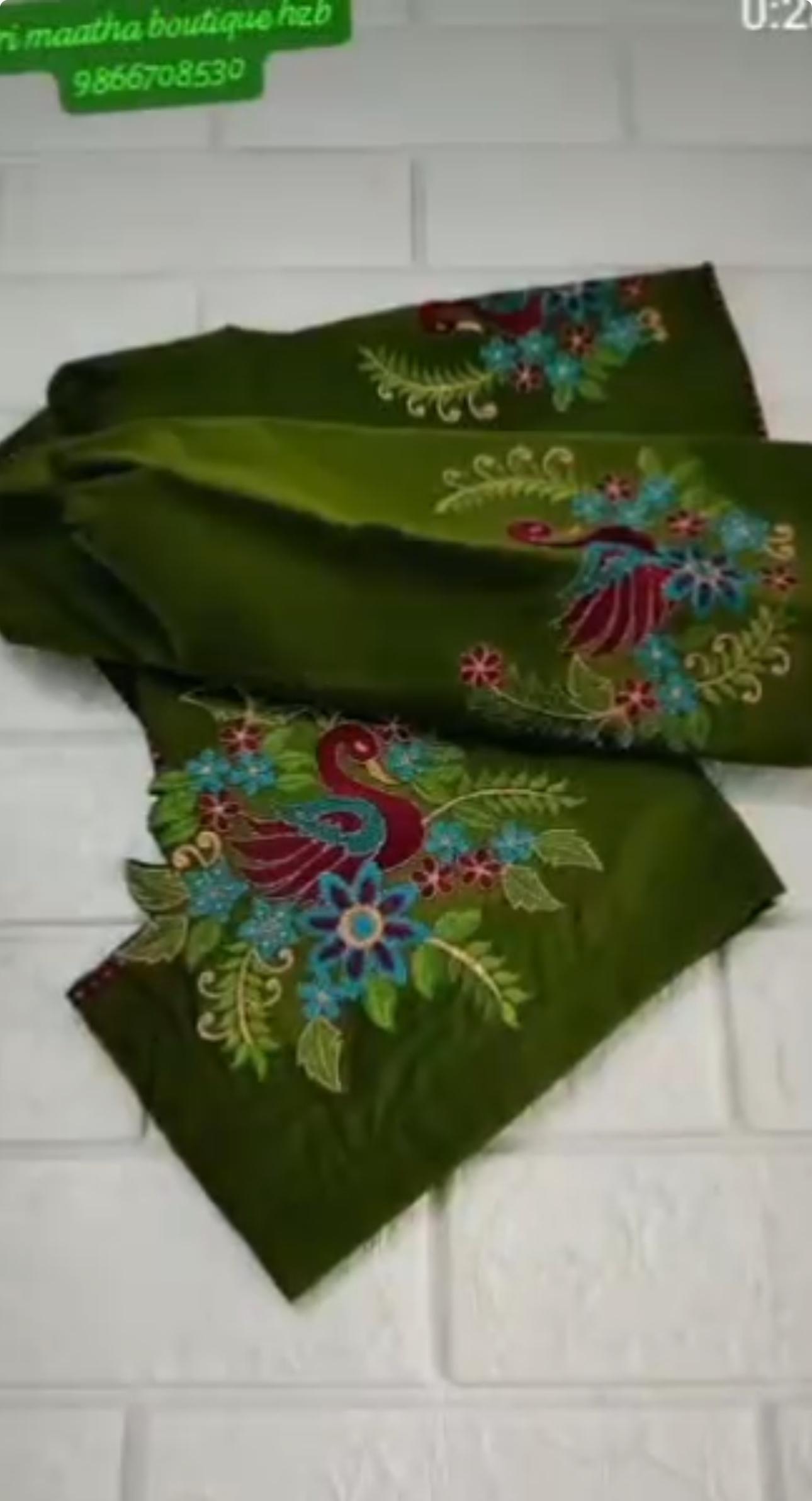 Green silk blouse with colorful floral embroidery and peacock design