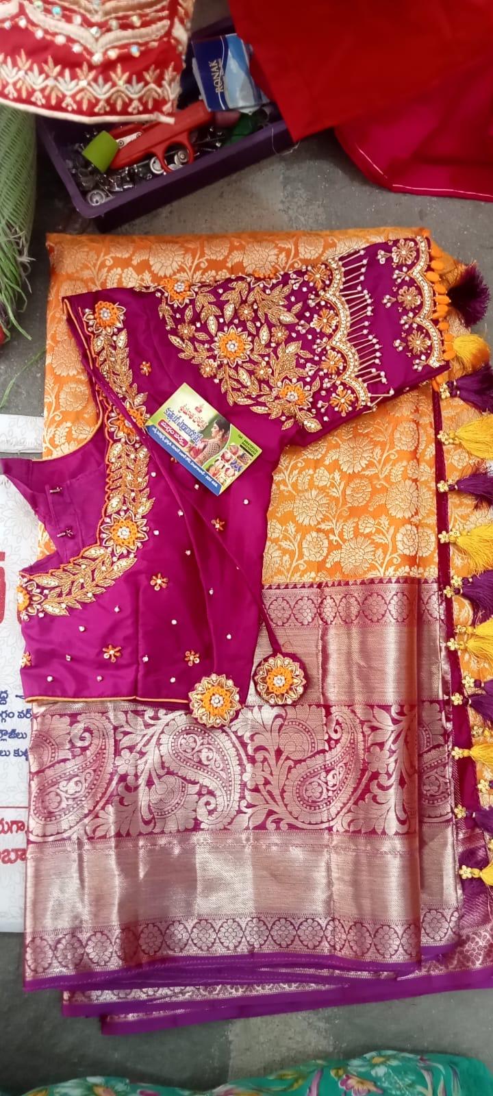 Magenta bridal blouse with gold embroidery and orange silk saree