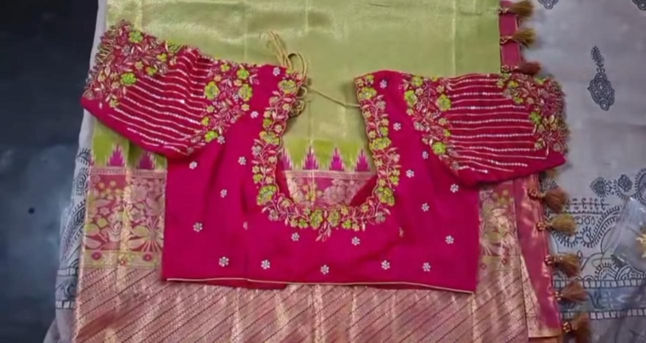 Magenta bridal blouse with elaborate maggam work and green floral embroidery