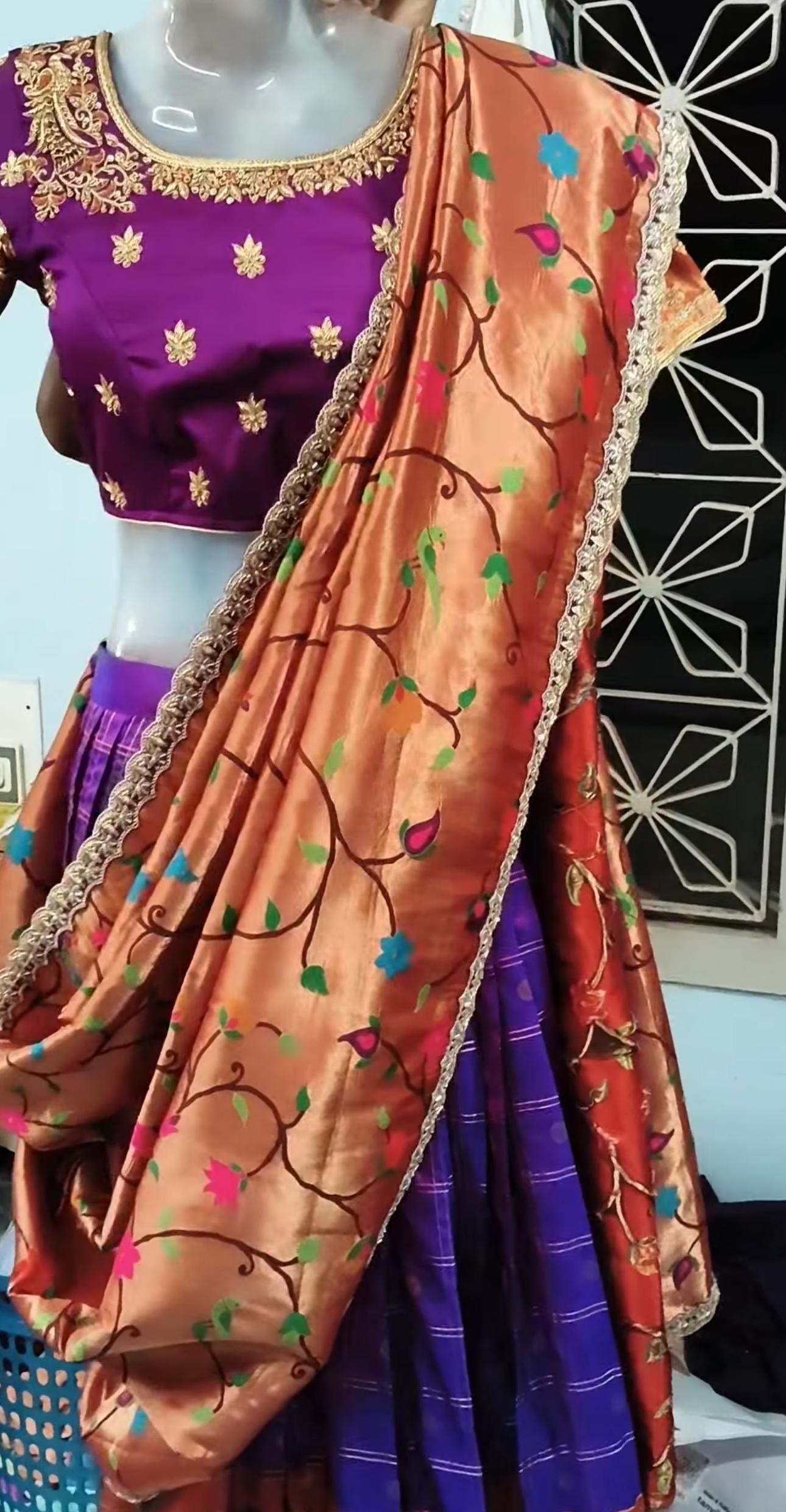 Purple blouse with gold zari work paired with floral patterned half saree