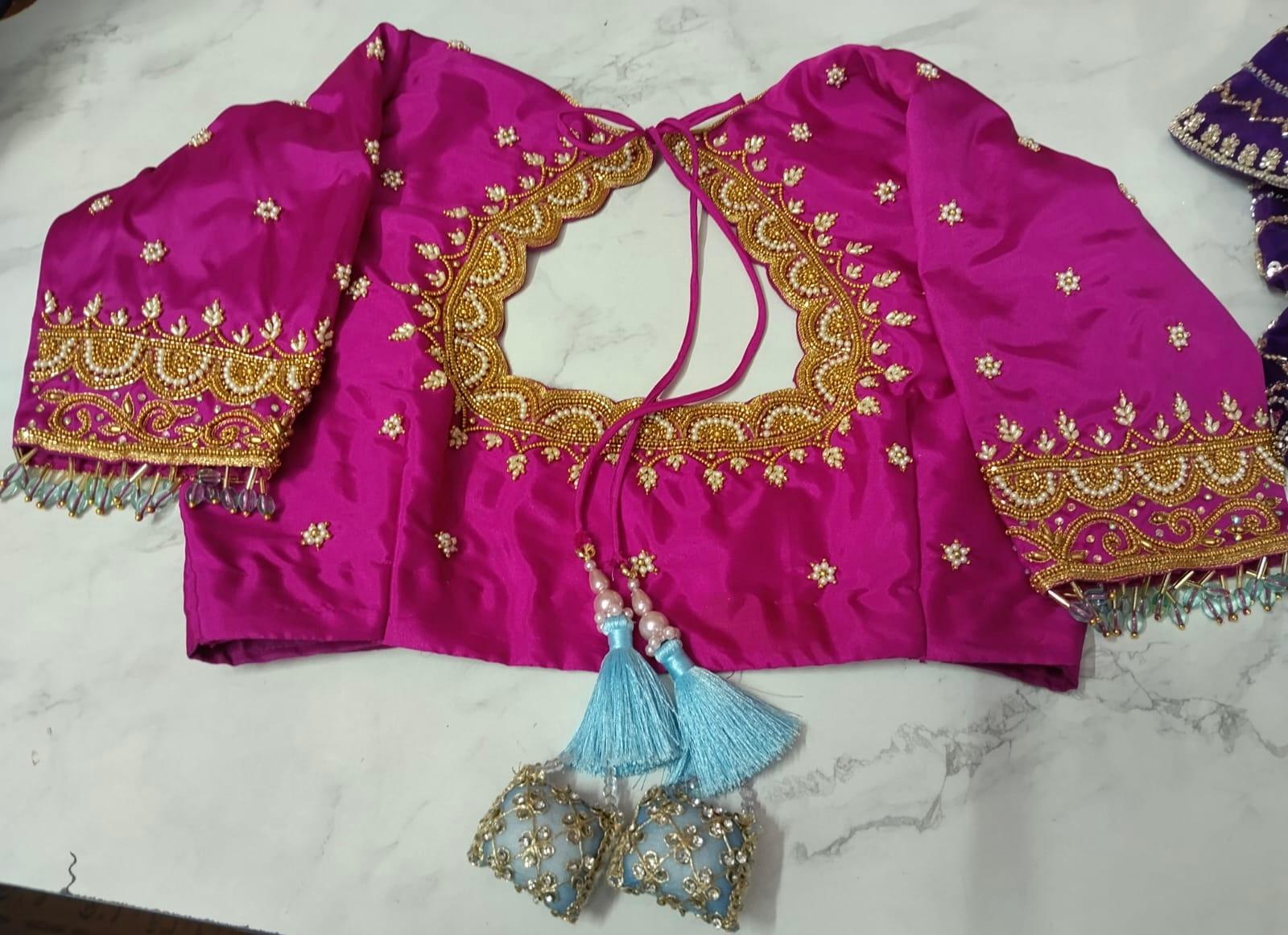 Magenta bridal blouse with gold zari embroidery and tassel details