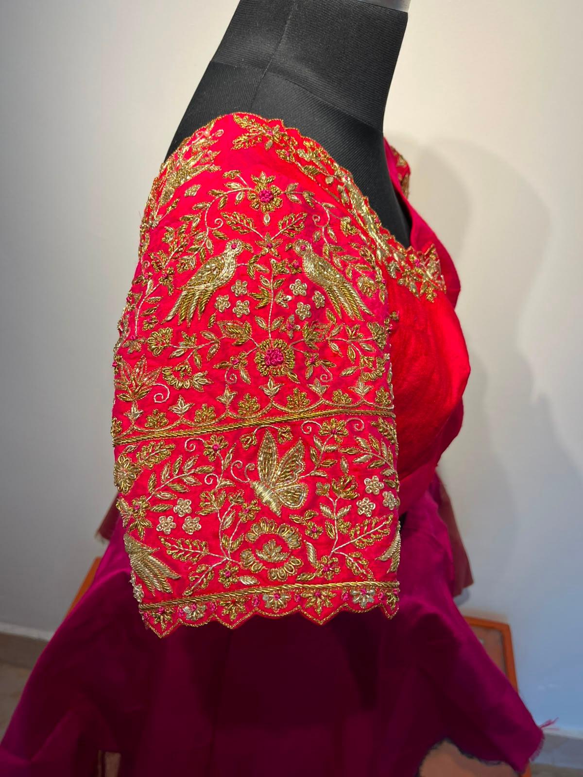 Red bridal blouse with intricate gold zari embroidery and floral motifs
