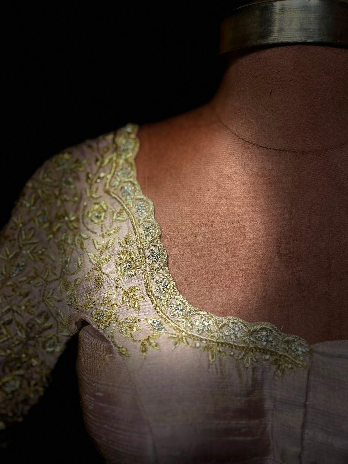 Cream blouse with intricate gold zari embroidery and ornate neckline