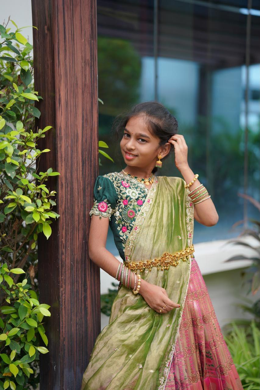 Green half saree with floral embroidered blouse and pink patterned skirt
