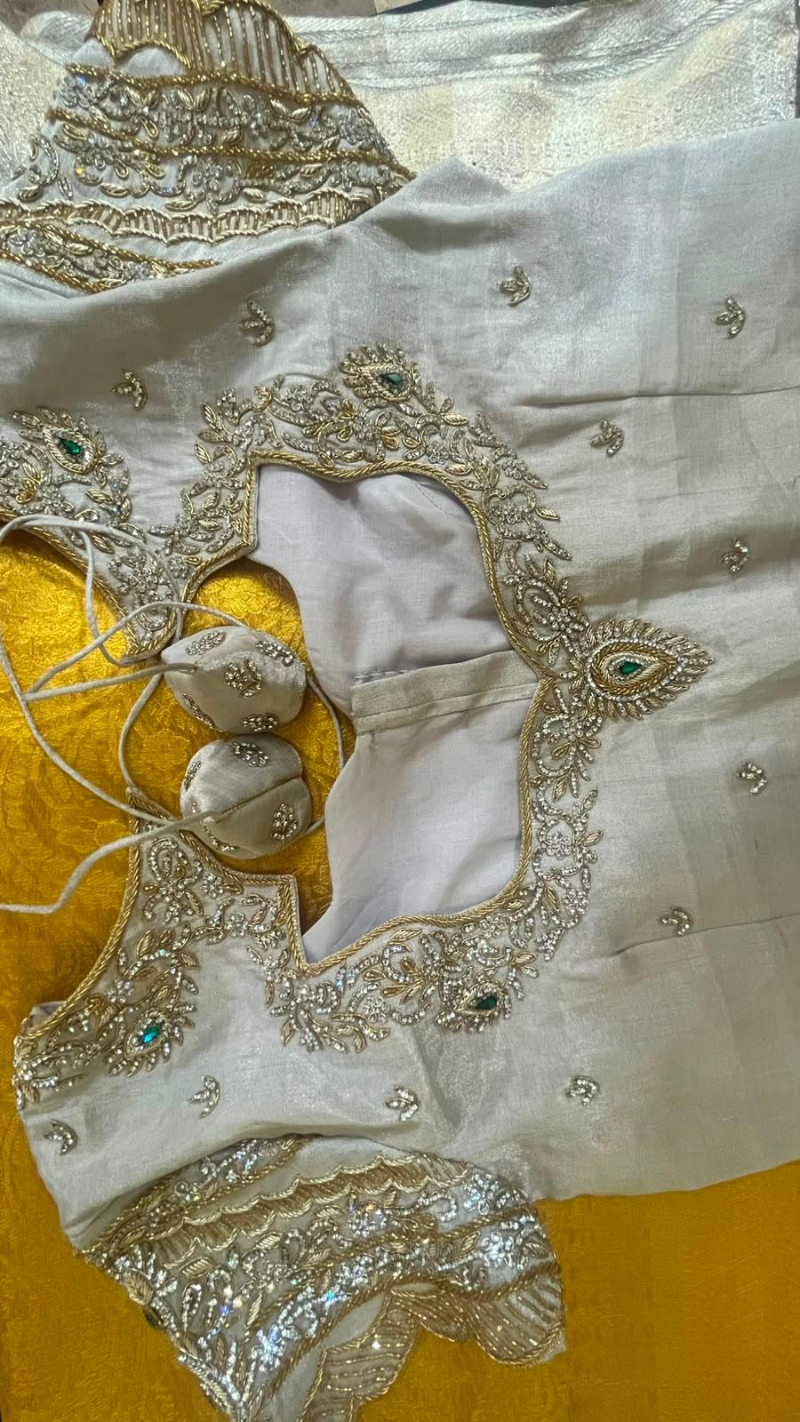 Cream bridal blouse with intricate gold zari and Swarovski stone embroidery