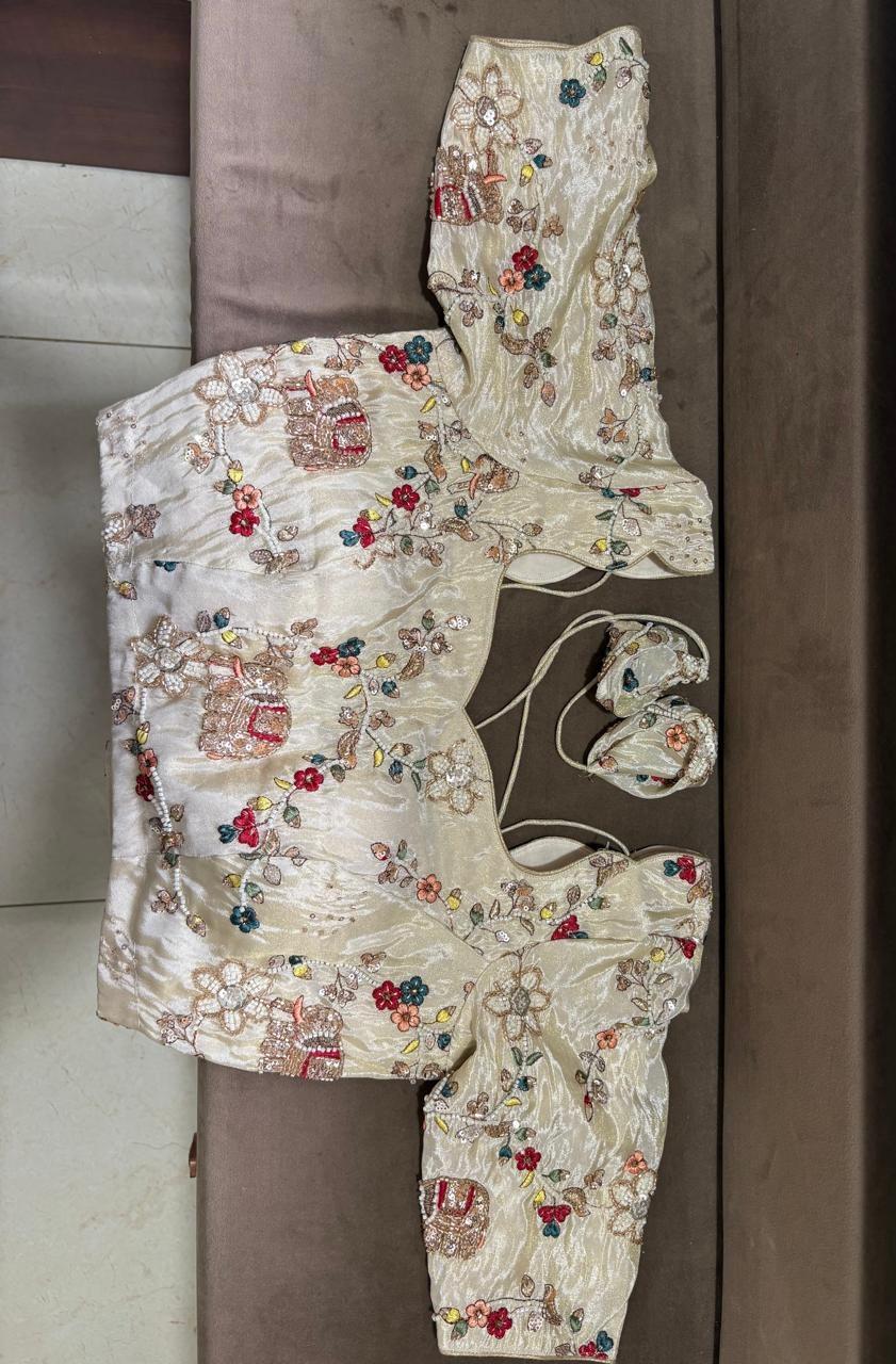 Cream bridal blouse with colorful floral and geometric maggam work embroidery