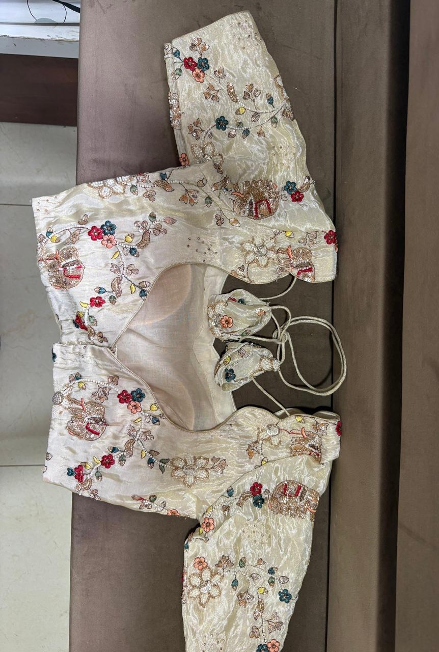 Cream embroidered blouse with colorful floral maggam work and matching drawstring potlis