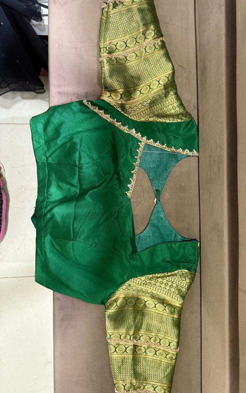 Green silk blouse with cutout details and gold zari patterned saree