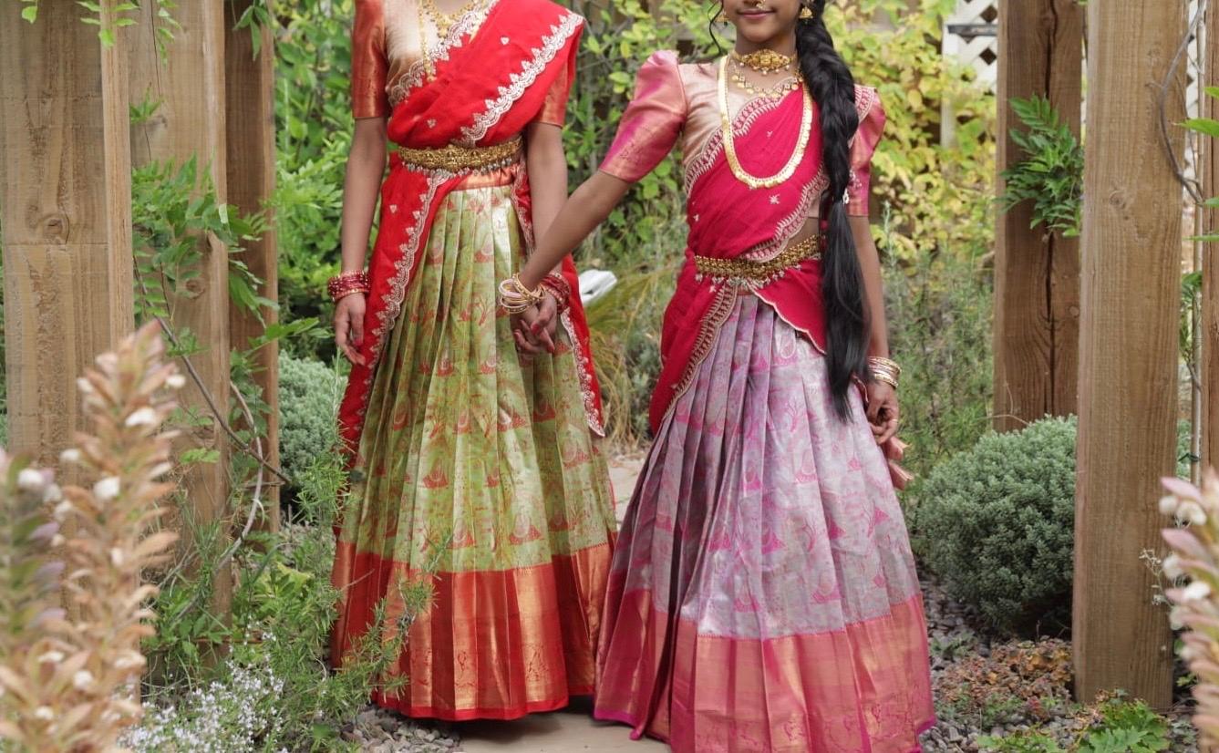 Red and green silk half saree with gold zari embroidery and floral patterns