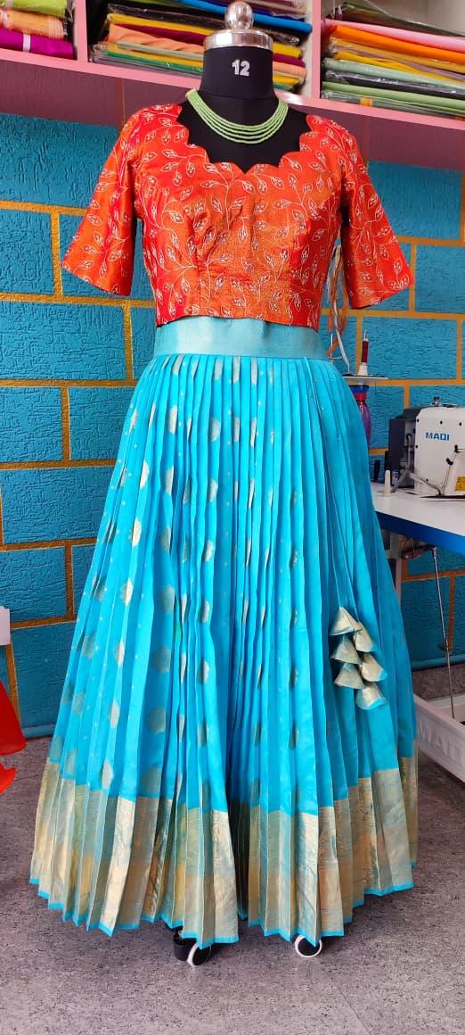 Red floral blouse with turquoise pleated skirt and gold border