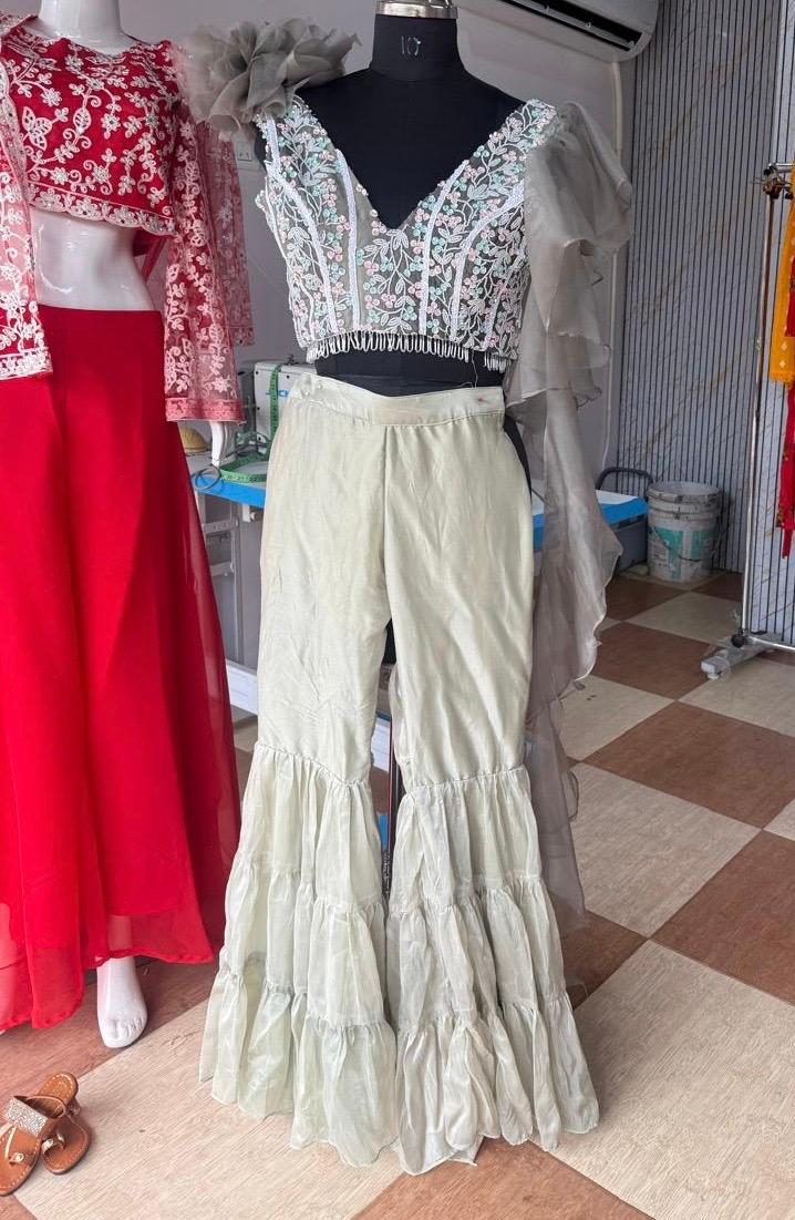 Cream tiered ruffle pants with white embroidered crop top blouse