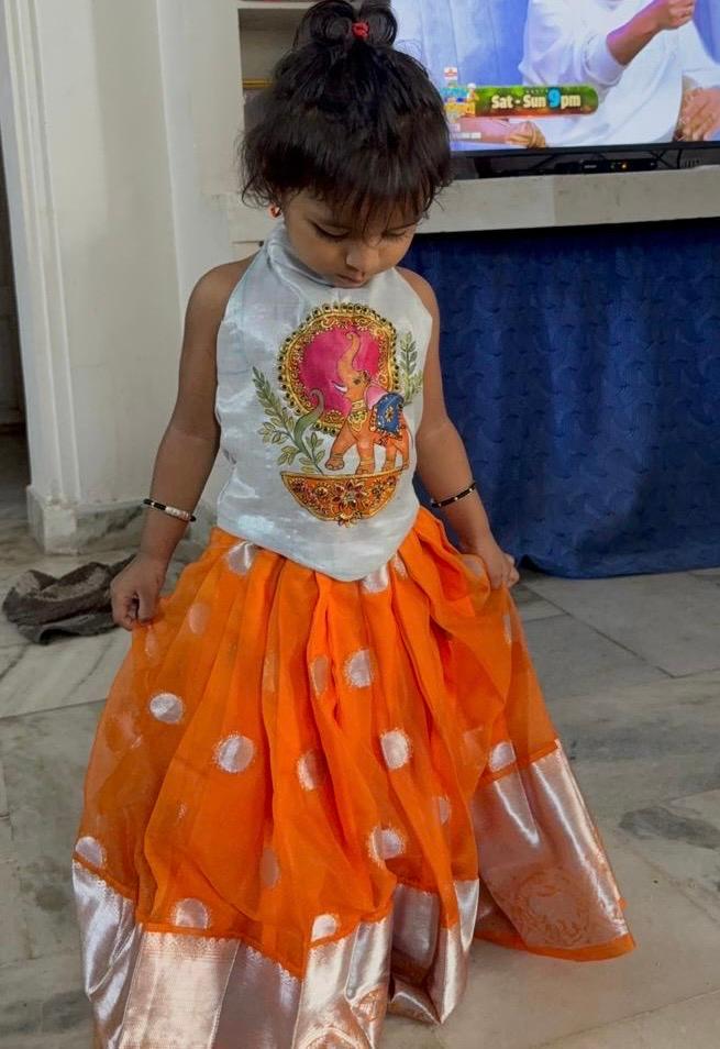 Orange silk skirt with white polka dots and traditional gold-embellished pink top