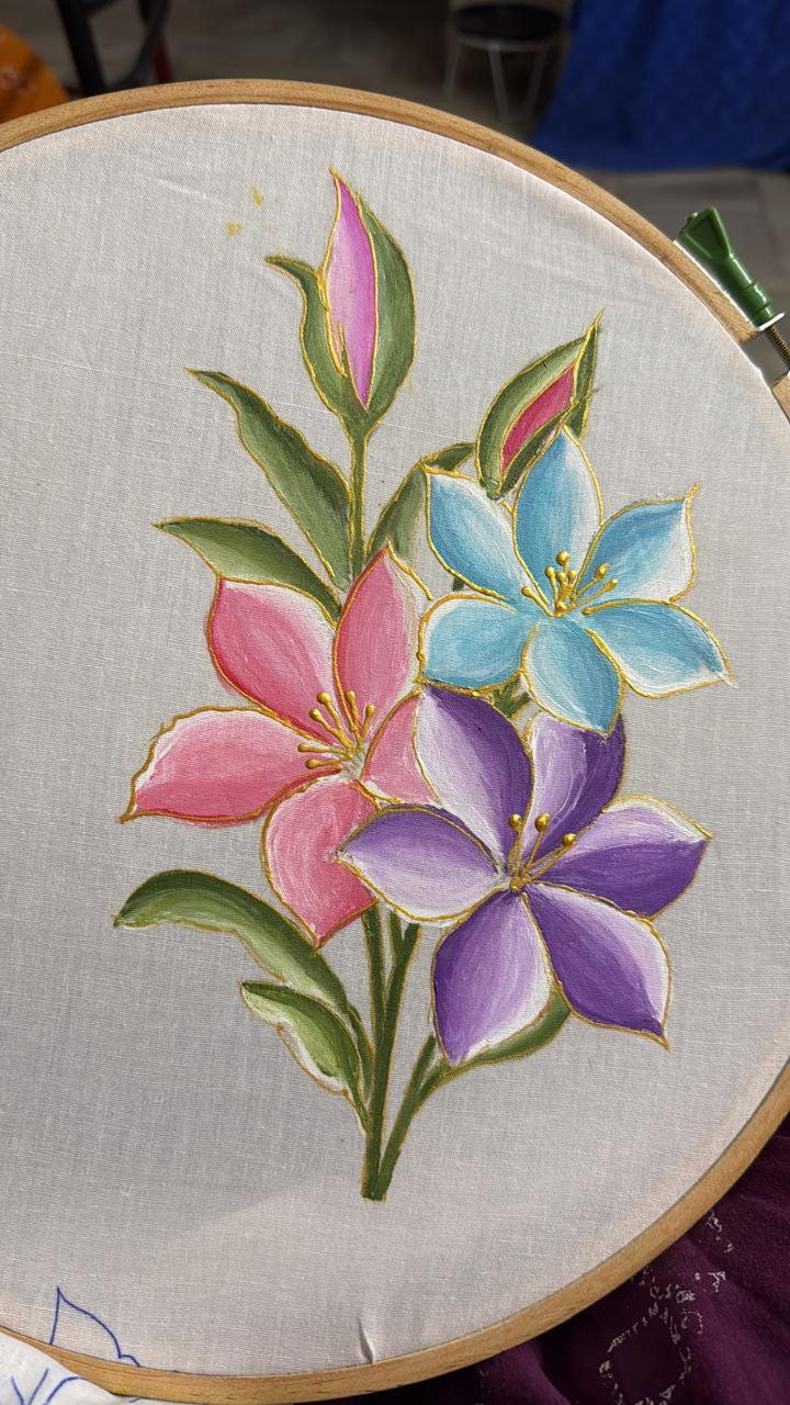 Embroidered floral hoop art with pink, blue, and purple blooms
