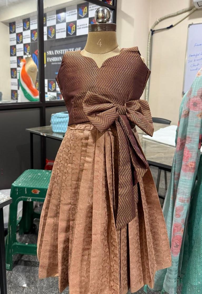 Brown textured blouse with bow detail and patterned skirt