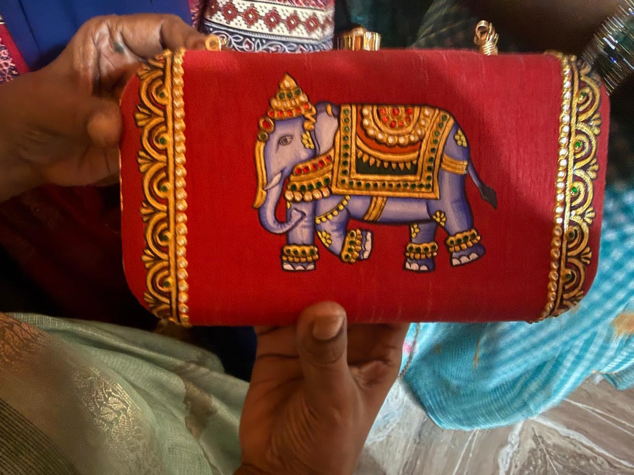 Red clutch with embroidered purple elephant and gold ornamental details
