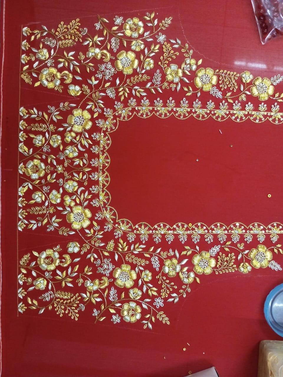 Red saree with gold zari floral embroidery and decorative borders