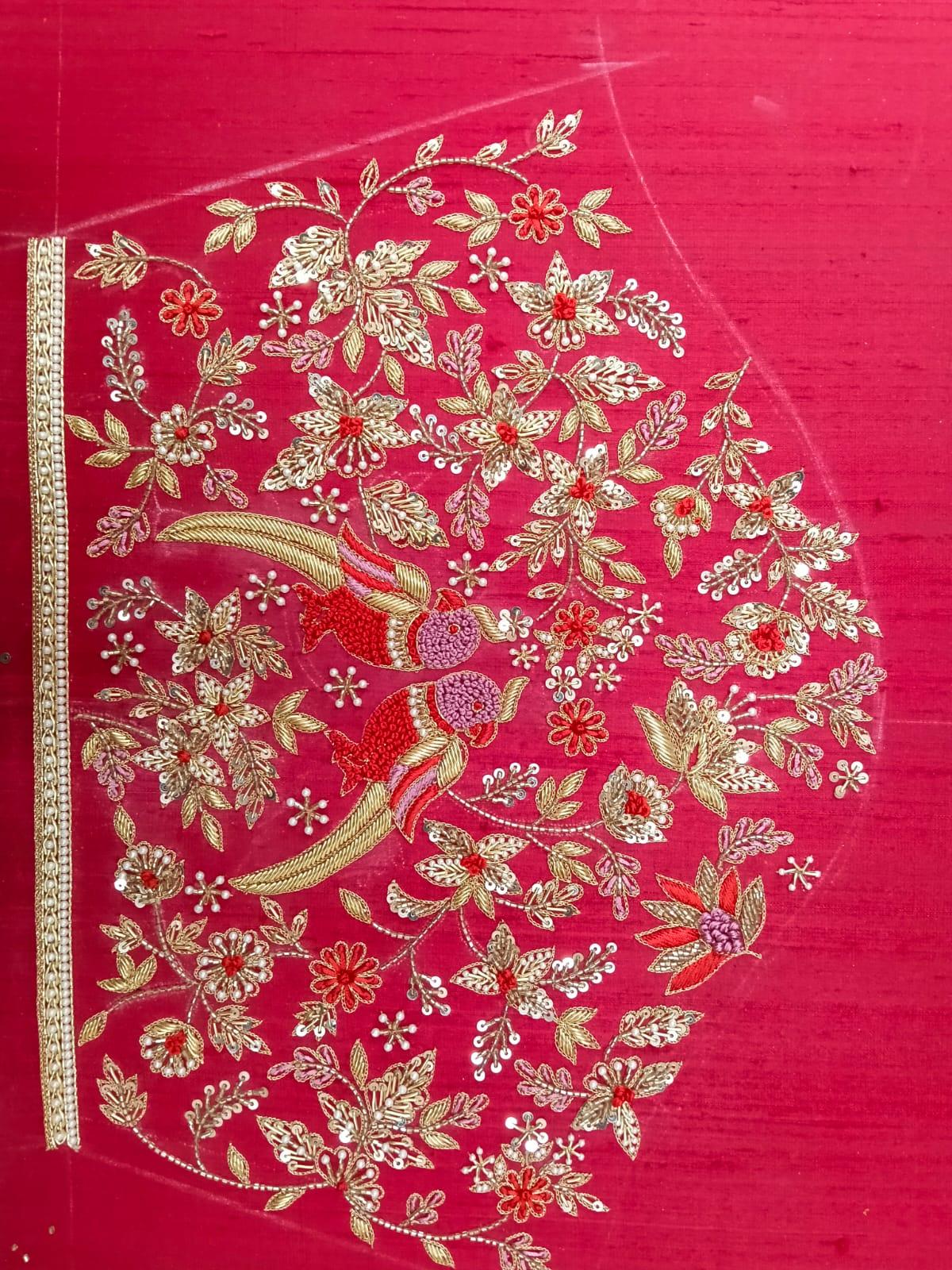 Red silk fabric with elaborate gold zari floral embroidery and parrot motifs