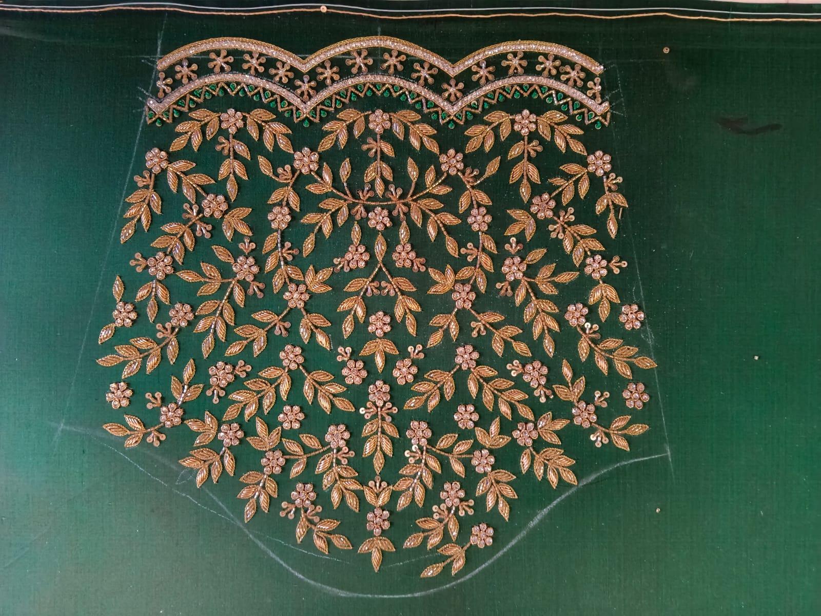 Green bridal blouse with gold zari floral embroidery and beaded neckline