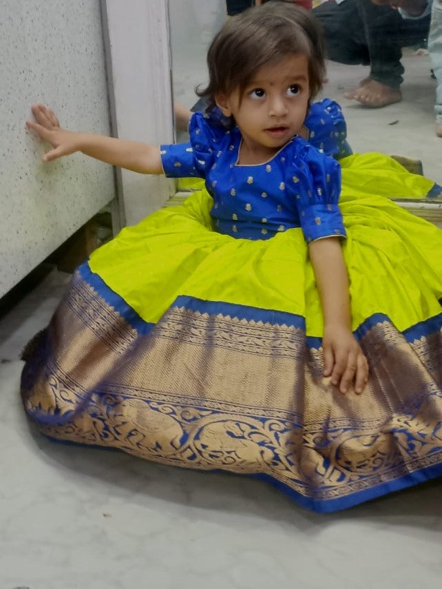 Elegant girls traditional pattu pavadai dress with a royal blue blouse, parrot green skirt, and rich zari border. — Girls Traditional Outfit Design