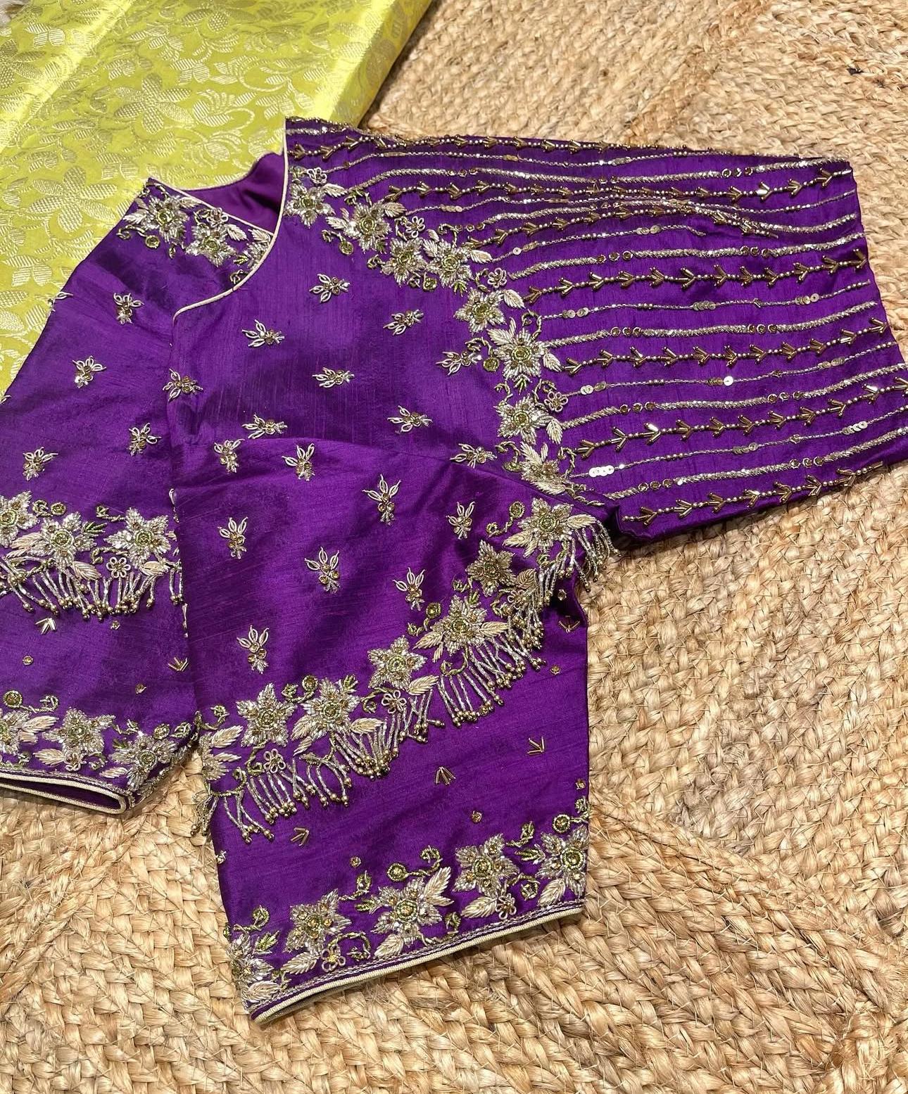 Elegant purple bridal blouse featuring floral zari embroidery, intricate sleeve work, and tassel detailing, perfect for weddings and festive occasions.