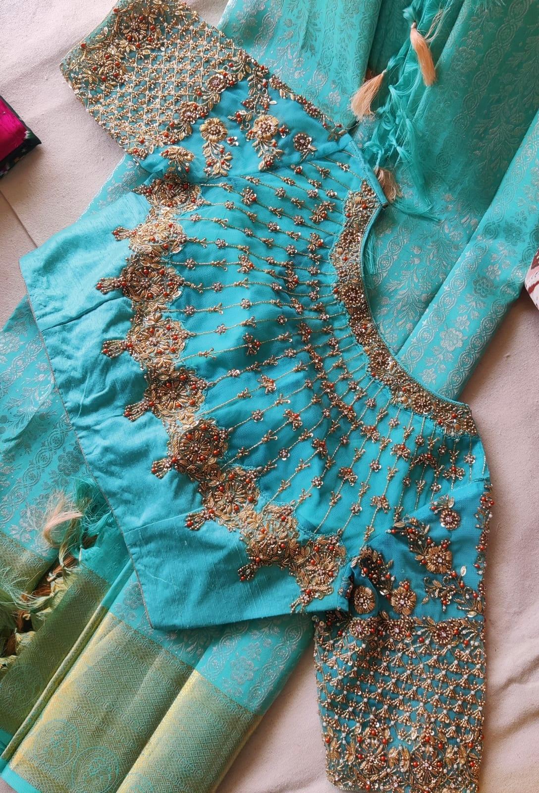 Elegant aqua blue bridal blouse featuring intricate maggam work, heavy stone embroidery, and designer sleeve detailing, perfect for weddings and festive occasions.