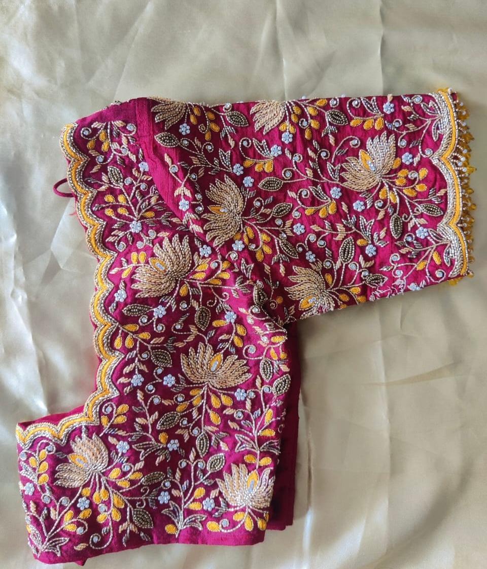 Elegant pink bridal blouse featuring floral maggam embroidery, scallop sleeve detailing, and premium handwork for weddings and festive occasions.